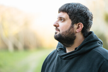 Deaf man using hearing aid outdoors in natural surroundings during a calm day