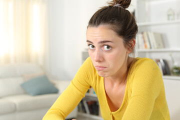 Naklejka premium Perplexed woman looking at you at home