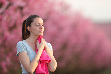 Sportswoman drying sweat with a towel in nature