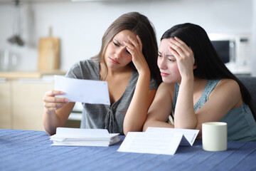 Worried interracial lesbian couple checking bank statement