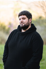 Deaf man with hearing aid stands confidently in nature during daytime, showcasing the beauty of inclusivity and technology