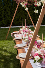 Long candles wit pink and white flowers on festive table. Visuals for event planning and design...