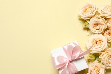 Beautiful composition with peony roses and gift box on color background