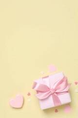 Beautiful composition with gift box and pink hearts on color background