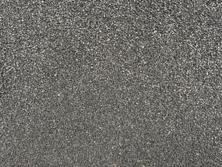 Textured surface of fine gravel in uniform gray.