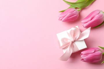 Beautiful fresh tulips with gift box on color background