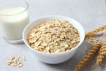 Composition with oatmeal flakes on gray background. Cooking breakfast