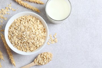 Composition with oatmeal flakes on gray background. Cooking breakfast