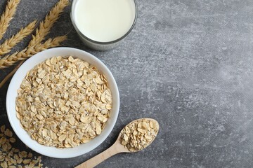 Composition with oatmeal flakes on gray background. Cooking breakfast