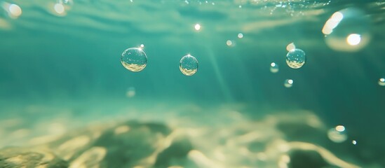 Close up of underwater bubbles in clear turquoise ocean water with a bokeh effect and sunlight filtering through the surface creating a serene atmosphere