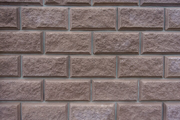 Background - brownish pink split face brickwork with stretcher bond pattern