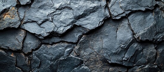 Textured dark grey black slate background with natural cracks and grooves suitable for a variety of design and architectural applications.