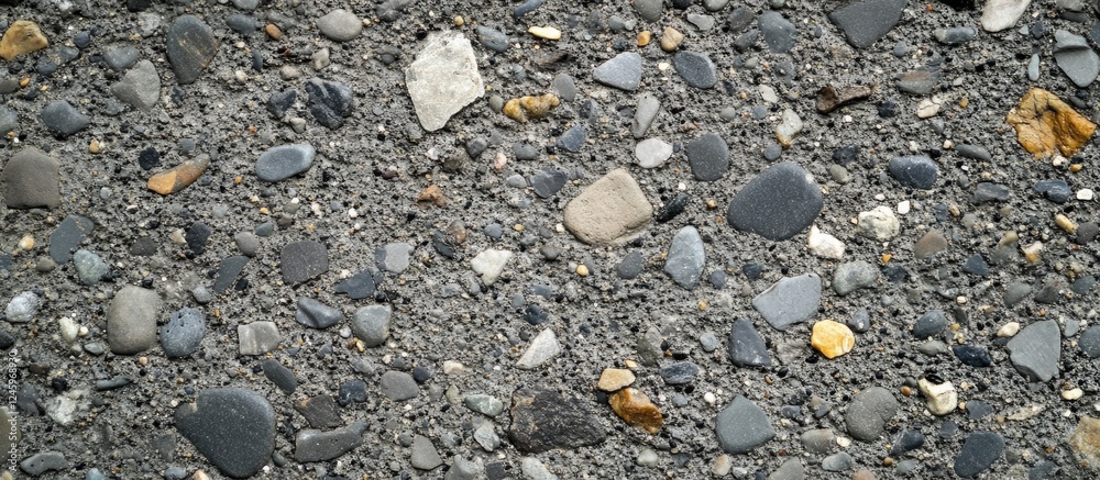 Aufkleber Textured concrete floor with pebbles and gravel showcasing natural patterns and muted tones for industrial or architectural applications.
