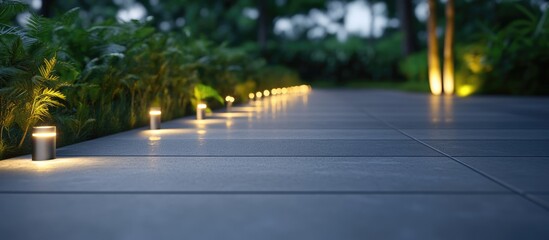 Naklejka premium Modern illuminated pathway with stylish lamps highlighting the walkway surrounded by lush greenery at night.