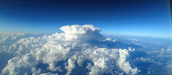 Vast Cumulus Clouds Accumulating Under a Clear Blue Sky Captured from an Airplane Window Perspective