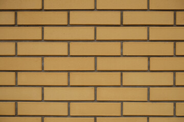 Texture of sand yellow smooth brick wall with running bond