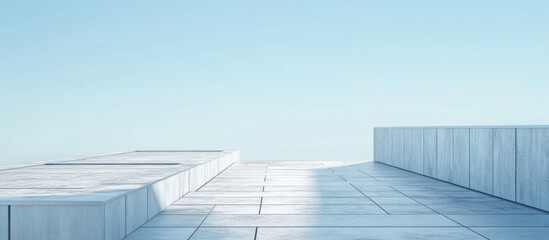 Obraz premium Modern minimalist rooftop with gray tiles against a clear blue sky ideal for architectural or design backgrounds.