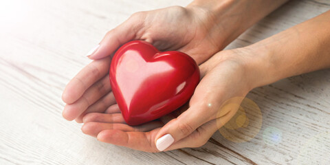 Abstract background. Valentine's Day concept with care from a lover and a red heart in hand. care,...