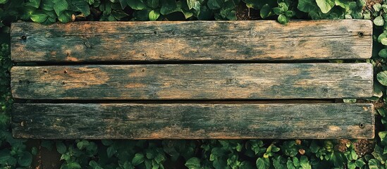 Fototapeta premium Rustic Weathered Wooden Bench Surrounded by Greenery Ideal for Outdoor Landscapes and Nature Settings