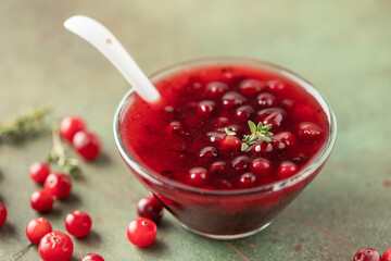Homemade cranberry sauce in glass bowl. Fresh berry and thyme