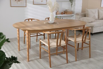 Stylish wooden table with chairs and decor indoors. Interior design