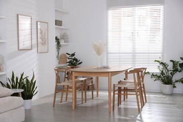 Stylish wooden table with chairs and decor indoors. Interior design