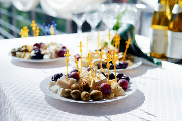 Decorated Plates of Appetizers with Olives, Cheese, and Grapes on a Table..