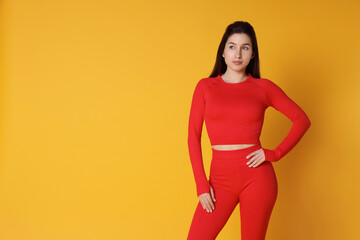 Obraz premium Portrait of woman in sportswear on orange background, space for text