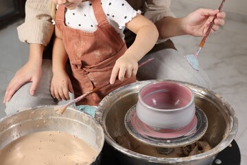 Hobby and craft. Daughter with her mother making pottery indoors, closeup