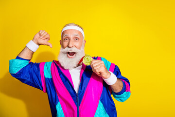 Photo of funny aged sportsman point finger himself hold medal retro uniform isolated on yellow...