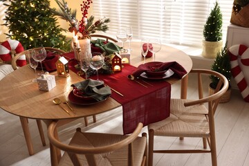 Christmas table setting with stylish dishware and festive decor indoors