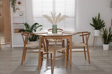 Stylish wooden table with chairs and decor indoors. Interior design