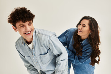 Young stylish friends enjoying a fun moment in trendy denim outfits