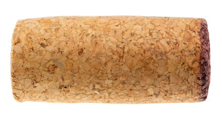 Detailed close-up of a used wine cork with textured surface and a red wine-stained edge isolated on...