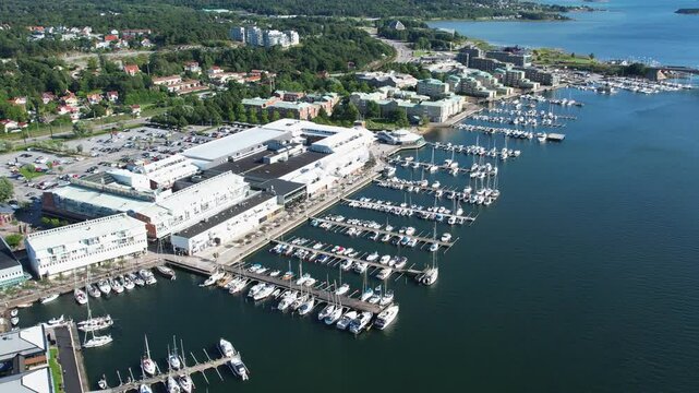 Pull out drone shot of Stenungsund hamn with boats and blue water in the day in Bohuslan, Sweden