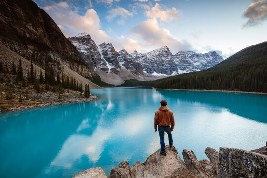 Man standing near Moraine lake at sunset, Banff, Canada
