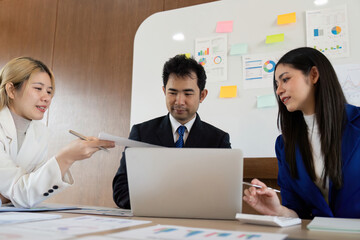 Collaborative business team discussing analysis and sharing reports during a strategy meeting in a modern office.