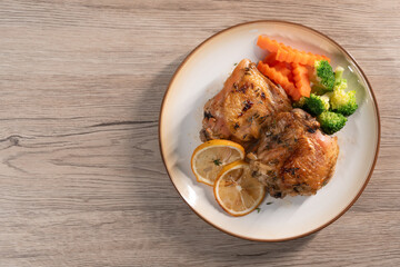 Baked Chicken Thighs with Lemon on wood background. Top view