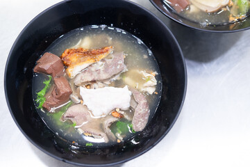 Boiled pork entrails and blood jelly soup in black bowl you can eat couple with rice