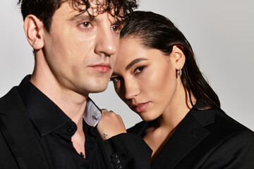Fashionable young couple posing confidently in stylish attire against a minimal backdrop