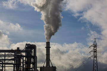 Chimney with smoke from a wood processing industry and an electric power pole. Electricity with...