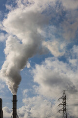 Chimney with smoke from a wood processing industry and an electric power pole. Electricity with...