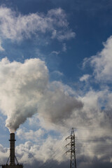 Chimney with smoke from a wood processing industry and an electric power pole. Electricity with...
