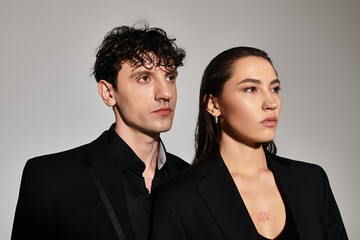Elegant young couple exuding stylish charm in a minimalistic studio setting