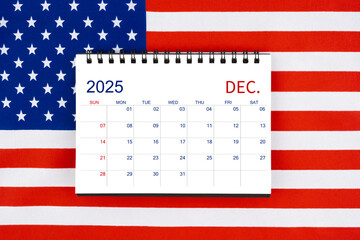 December 2025 desk calendar on United States of America flag.