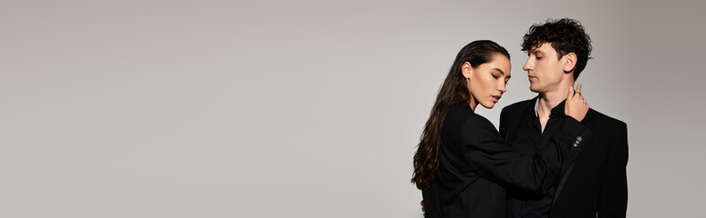 Stylish young couple embraced in a modern fashion shoot set against a minimal backdrop