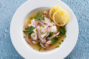 Traditional Peruvian ceviche sea bass fillet on blue background