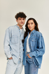 Young stylish couple showcases trendy denim looks in a modern indoor setting