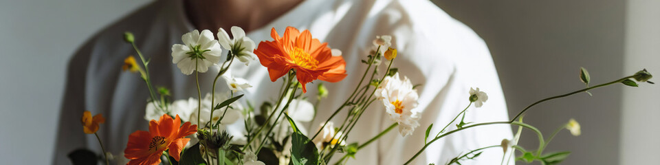 Person Holding Bouquet of Orange and White Wildflowers