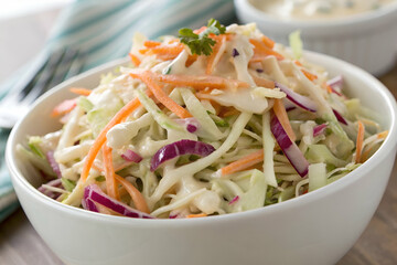 Summer BBQ Party, A fresh and colorful bowl of coleslaw featuring shredded cabbage, carrots, and a creamy dressing, perfect for summer meals or picnics.
